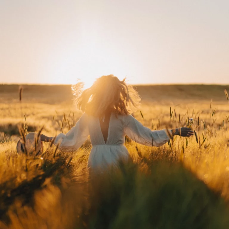 Young beautiful woman with long blond hair white dress wheat field early morning sunrise summer is time dreamers flying hair woman running across field rays