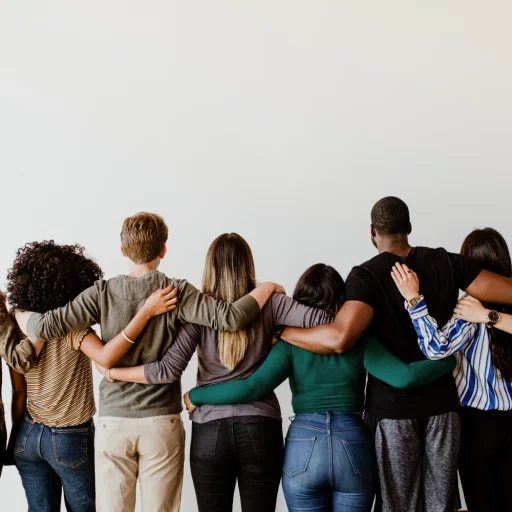 Rearview diverse people hugging each other