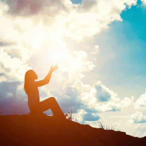 Silhouette woman with raised hands